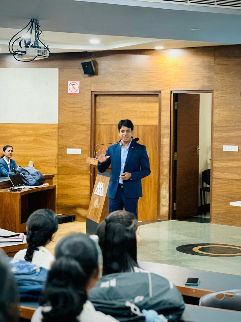 Umesh speaking at a podium to MBA students