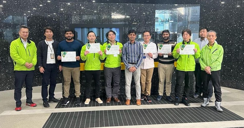 Green Belt graduates holding certificates in Japan